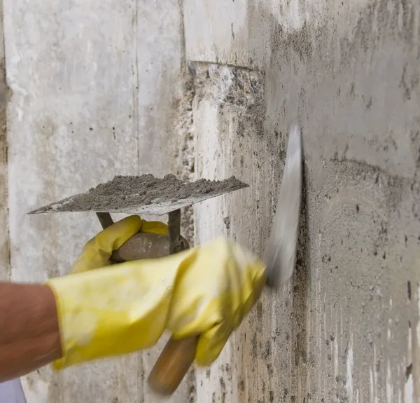 Repair mortar applied by trowel to a concrete wall